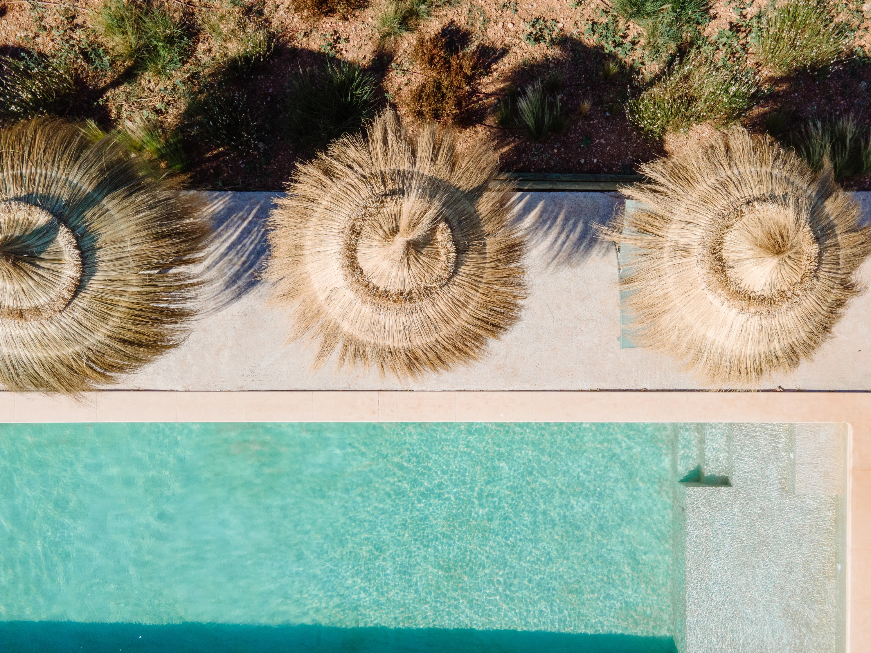 Casa Mana — poolside view with palm parasols