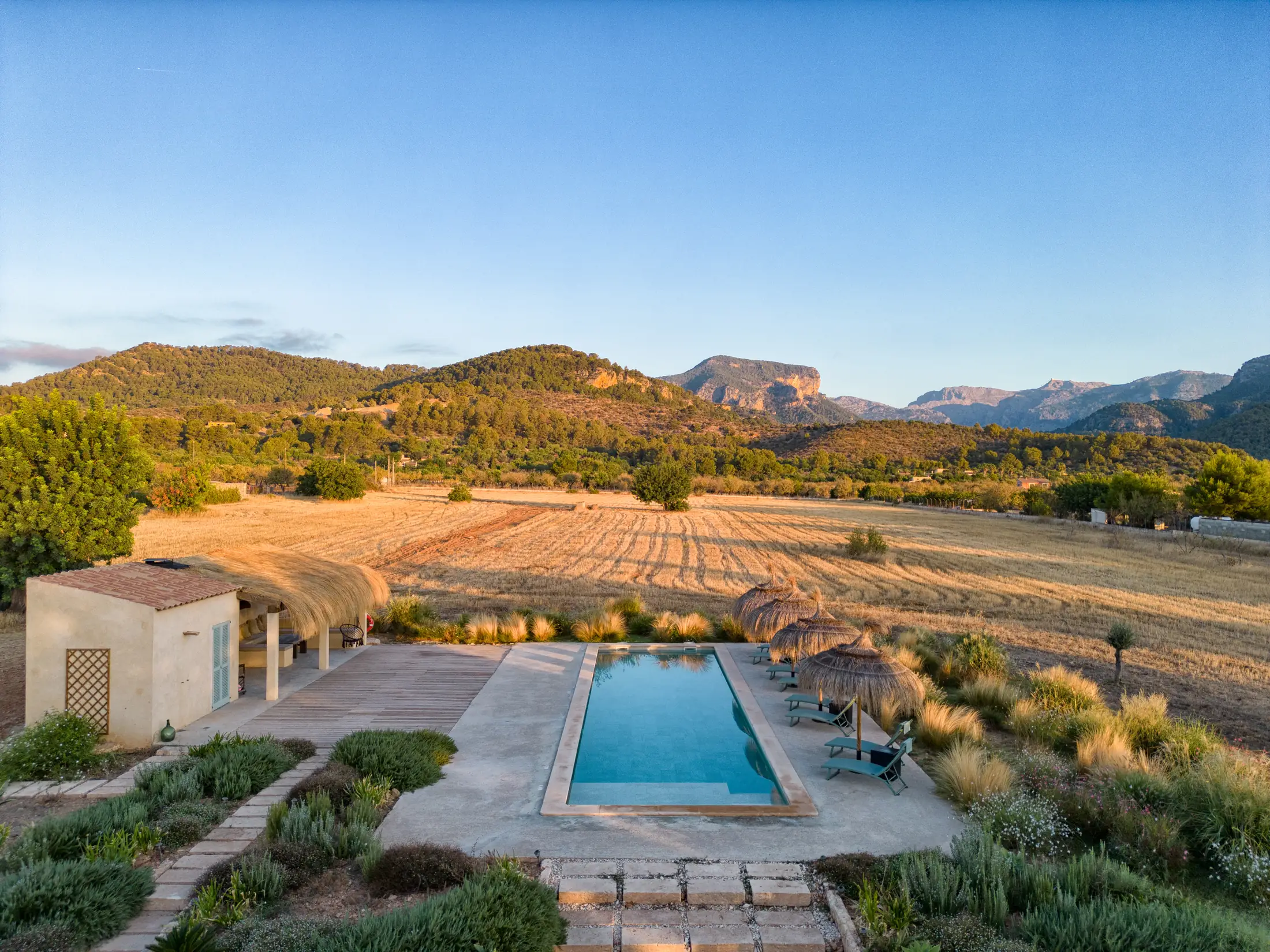 Casa Mana — the 15-metre saltwater pool surrounded by garden, covered terrace and mountain backdrop