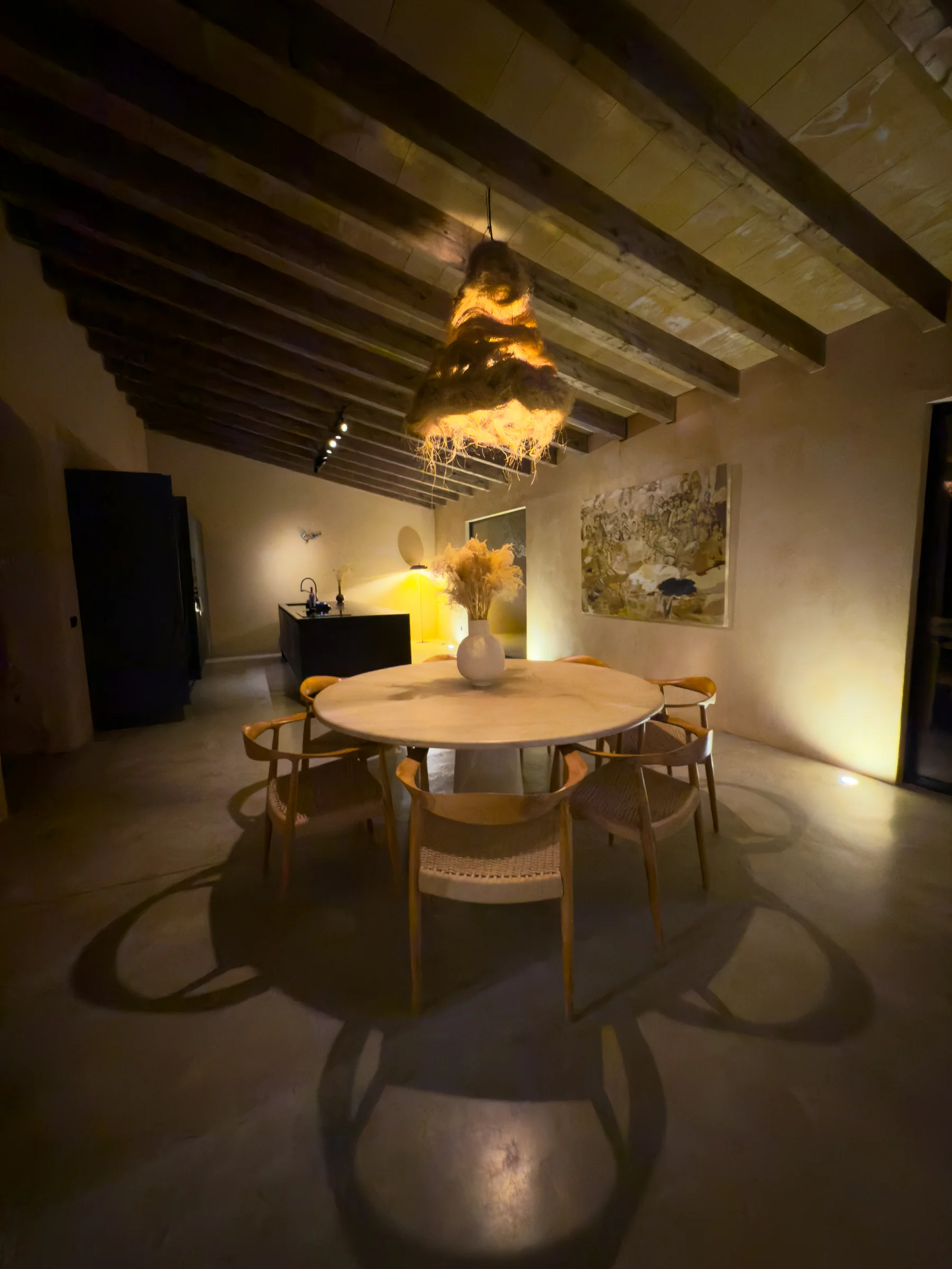 The dining table at dusk — warm light and the sculptural hanging lamp