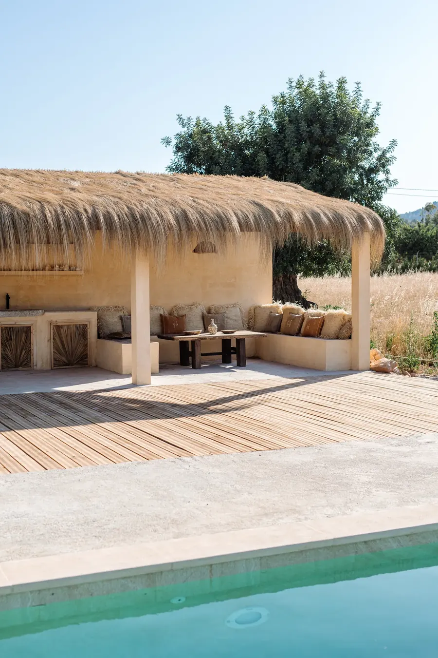 The chiringuito — thatched shade, built-in seating and the pool a step away