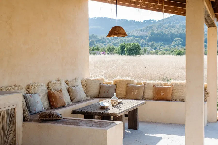 The covered terrace — textured cushions, warm light and countryside views