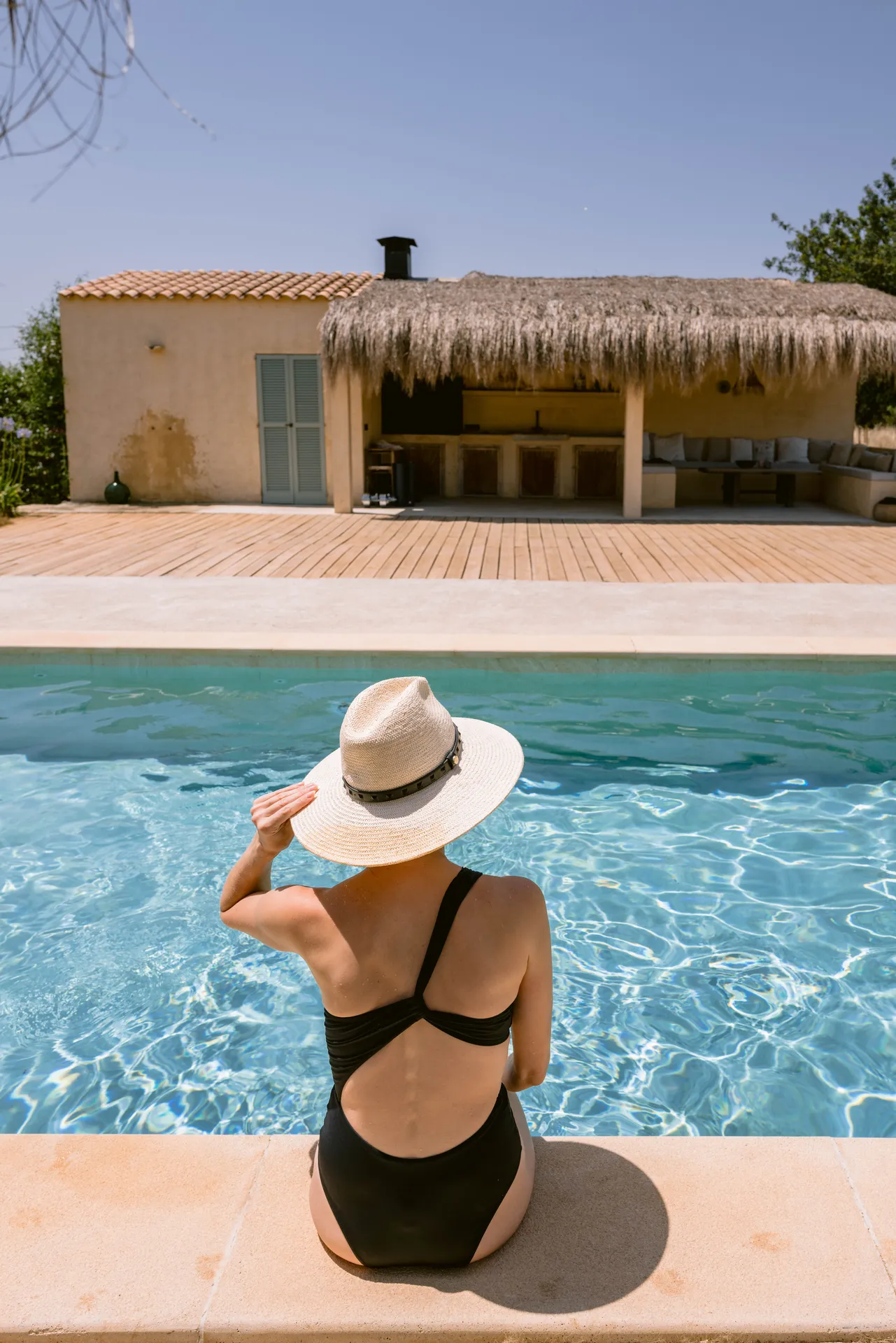 A quiet afternoon at the pool — sun hat, still water and the finca beyond